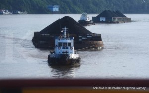 Kapal pengangkut batubara melintasi Sungai Mahakam, Samarinda, Minggu (31/12).